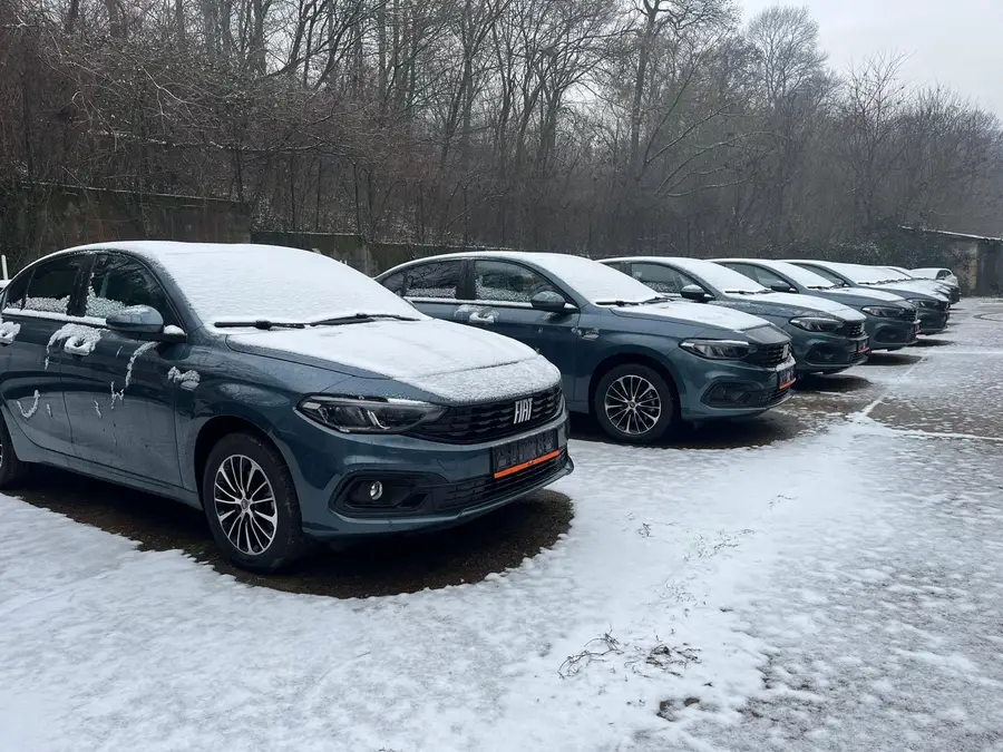 Red putničkih vozila sa zimskim gumama na snežnom parkingu