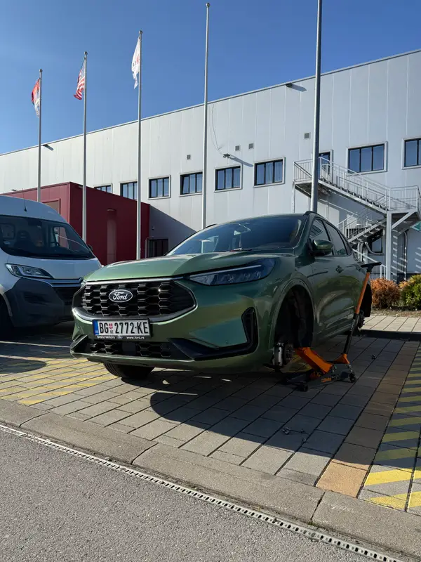 Ford podignut dizalicom tokom zamene gume na parkingu